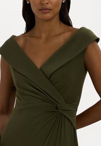 Olive green dress with a fitted bodice, off-the-shoulder neckline, twisted detail at the waist, and soft, smooth fabric texture.