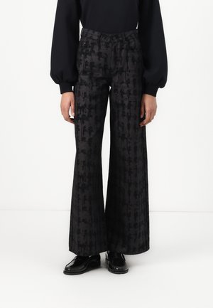 Zijdelengte pantalons van zwarte stof met een subtiel patroon, hoge taille en vo pockets. Gestyled met een strak zwart topje en zwarte schoenen.