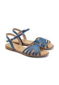 Niebieskie skórzane sandały z zapięciem na paski, z wcięciami, płaską podeszwą i paskami na kostkę z zapięciami na klamry.