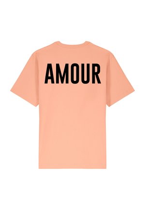 Sandyfarvet t-shirt med korte ærmer, med ordet "AMOUR" trykt i fed sorte bogstaver på ryggen. Blødt, letvægtsstof.