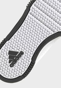 Valkoisen kumisen tennaripohjan kuusikulmaisella kuviolla, teksturoidulla pinnalla ja mustalla reunuksella. Sisältää tekstin "NON MARKING" ja logodetaljin.