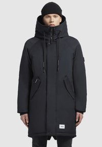 Jachetă parka neagră cu un guler înalt, închidere cu fermoar și capse, două buzunare laterale, material texturat și șnururi ajustabile pe glugă.