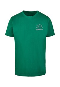 Grøn bomulds T-shirt med korte ærmer. Udstyret med et lotusblomstdesign og teksten "DIE FLIPPERS" i lysegrå. Normal pasform.