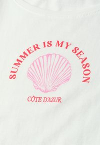 Graphique d'un coquillage rose avec le texte rouge « SUMMER IS MY SEASON » au-dessus et « CÔTE D'AZUR » en dessous sur tissu blanc.