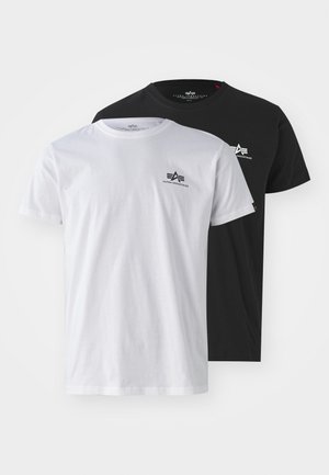 Deux T-shirts à manches courtes, un blanc et un noir, en coton, affichant un petit logo Alpha Industries sur la poitrine.