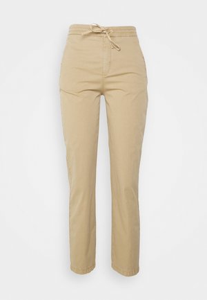 Pantalon beige droit avec une taille élastique et un cordon de serrage, poches avant, et une texture de tissu lisse et décontractée.