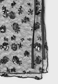 Zwarte kanten stof versierd met bloemsequins, met een transparante textuur en zwarte lintdetails langs de randen.