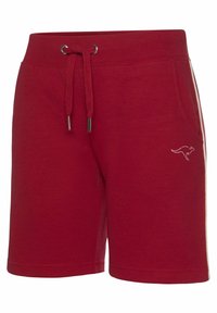 Red cotton shorts with an elastic waistband, drawstring, two side pockets, and a kangaroo logo, featuring a simple design and smooth texture.