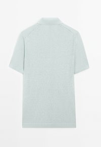 Světle modrá polo košile s krátkým rukávem, s žebrovaným límcem, bezšvovými rameny a měkkou texturou, vystavena s zadní stranou směrem vpřed.