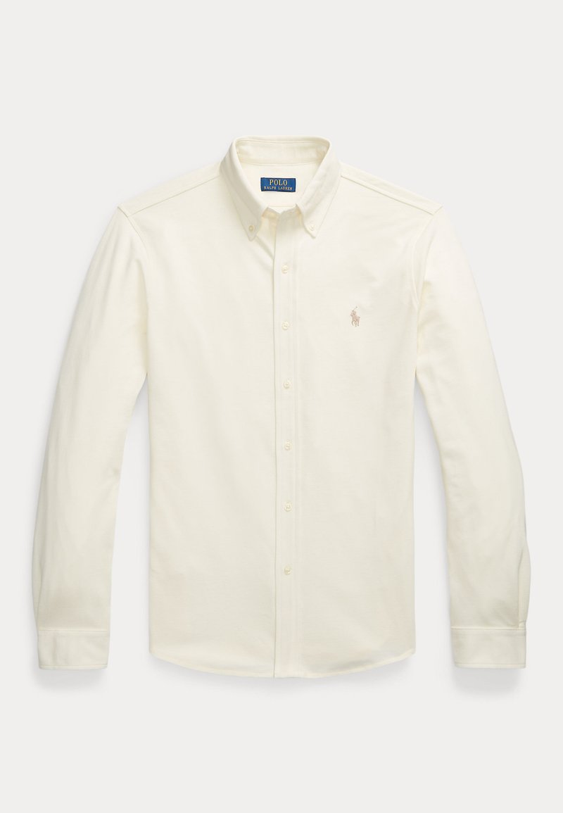 Kreminės spalvos ilgomis rankovėmis mygtukų marškiniai su prisagstyta apykakle ir mažuoju siuvinėtų Polo Ralph Lauren logotipu ant krūtinės.