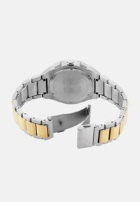 Reloj de hombre con pulsera de acero inoxidable y tono dorado, caja redonda, fondo resistente a los arañazos y cierre abatible.