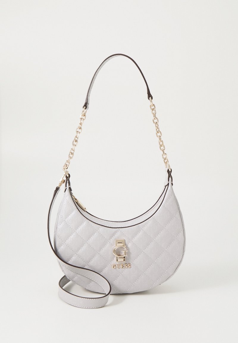 Lys grå quiltet halvmåneformet håndtaske med guld kædehåndtag og GUESS-logo på fronten, der har en ekstra skulderrem.