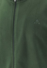 Grøn fleecejakke med en sort lynlås, der løber ned midt på, og et diskret broderet logo på venstre bryst.