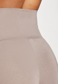 Højtaljede leggings i lys beige, lavet af glat, strækbart stof med en tætsiddende design og en sømløs linning.