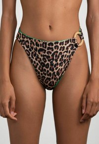 Costumi da bagno bikini con stampa leopardata, caratterizzati da un design a vita alta, bordi verdi e un accento in legno all'anca. Tessuto dal tocco liscio.