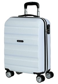 Maleta rígida blanca con diseño acanalado, acentos negros, mango extensible y cuatro ruedas giratorias para mayor movilidad.