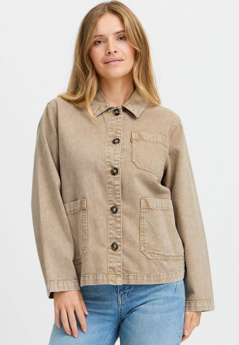 Beige denimjakke med krave, frontlukning med knapper, to store lommer og et let struktureret stof. Lange ærmer og afslappet pasform.