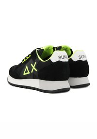 Scarpe sportive nere con tomaia in suede e mesh, caratterizzate da dettagli in verde neon e una linguetta posteriore bianca. Suola in gomma per una buona trazione.