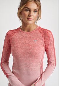 Langærmet træningstop i gradient nuancer af rød. Har en tekstureret finish, raglanærmer og et lille logo på brystet.