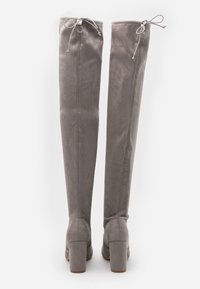 Botas de ante gris hasta la rodilla con punta redonda, taco cuadrado y cierre de lazo ajustable en la parte superior. Textura suave, diseño elegante.