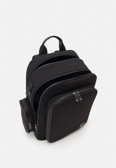 Mochila negra con un diseño elegante. Cuenta con múltiples compartimentos con cremallera, tela duradera y asas acolchadas para mayor comodidad.