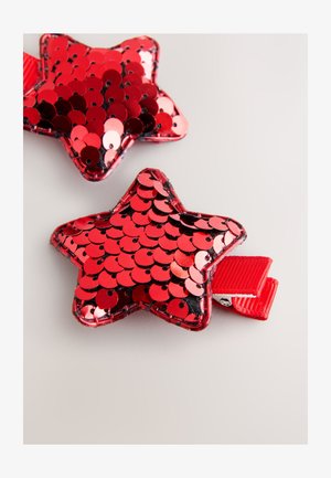 Red star-shaped clips covered in shiny sequins, featuring a smooth texture and a red ribbon attachment loop.