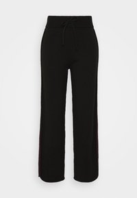 Zwarte gebreide broek met een taillekoord, met een ontspannen pasvorm en contrasterende zijpanelen in bordeauxrood. Zachte textuur, wijde pijpen.