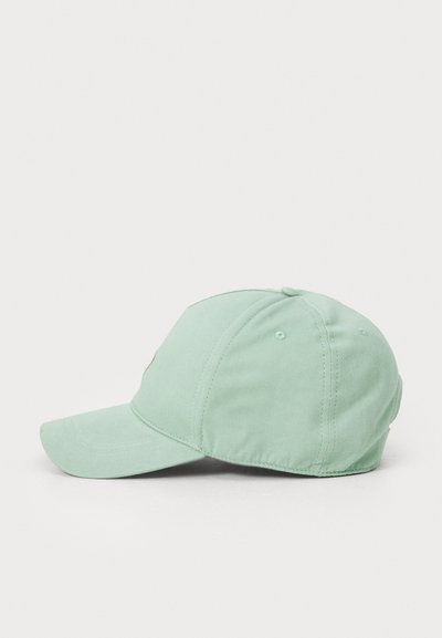 Mündroheline pesapalli müts, millel on kõver visiri, valmistatud pehmest puuvillast. Esiosas on õmmeldud logo ja külgedel ventilatsiooniavad.