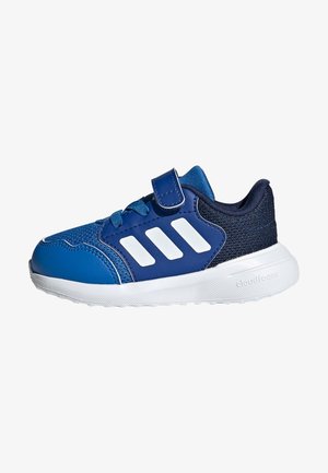 Shoe desportivo azul com parte superior em malha e sintético, faixa de velcro, realces brancos, bico redondo e sola de borracha branca texturizada.