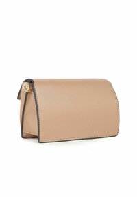 Beige lædertaske med en struktureret, rund form. Har sort kantning og en hængelås i guldfarvet metal. Glat tekstur, minimalistisk design.