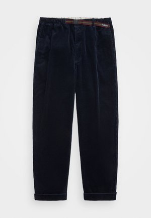 Donker marineblauwe corduroy broek met een gestreepte verstelbare riem en omgeslagen zomen, plat gelegd op een witte achtergrond.