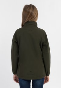 Giacca softshell verde oliva con colletto alto, polsini elastici e taglio dritto. Presenta un'etichetta con il marchio sull'orlo posteriore.