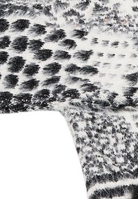 Černobílá strukturovaná tkanina s načechraným vzorem zvířecího tisku, která obsahuje zaoblené tvary a různou velikost po celém povrchu.