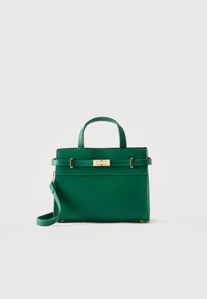 Πράσινη δερμάτινη τσάντα με χερούλι στο πάνω μέρος, κούμπωμα σε χρυσό τόνο και αποσπώμενο ιμάντα ώμου σε απλό ανοιχτό φόντο.