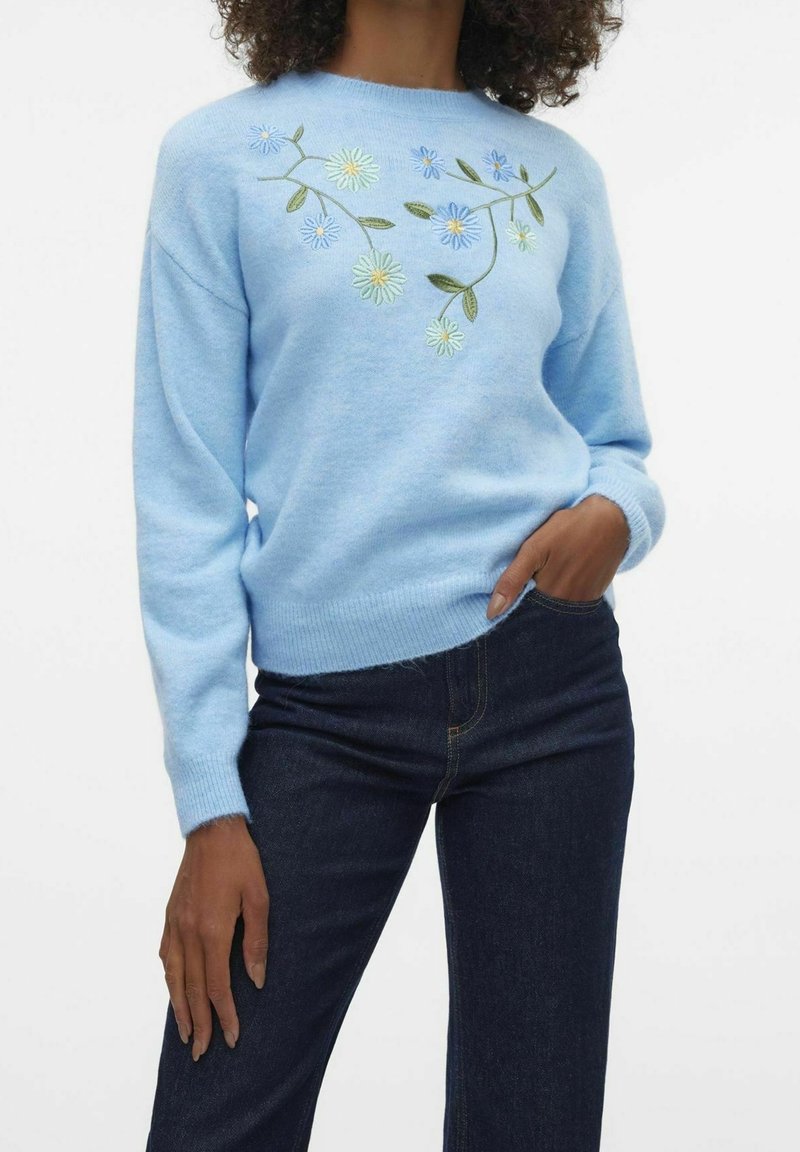 Light blue sweater made of soft fabric, featuring floral embroidery in blue, yellow, and green. Ribbed cuffs and hem, relaxed fit.