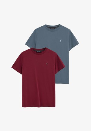 Dos camisetas de cuello redondo lisas, una en granate y otra en azul apagado, cada una con un pequeño logo blanco de un jugador de polo en el pecho izquierdo.