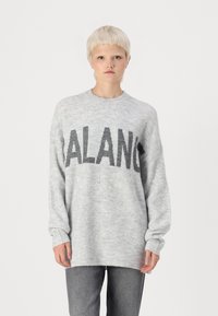 Szürke kötött pulóver kerek nyakkal, ejtett vállakkal és feltűnő "BALANC" felirattal a mellkason. Puha textúra és laza fazon.
