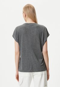 Harmaa lyhythihainen t-paita, jossa on rento istuvuus, pyöreä pääntie ja sivuaukot, valmistettu pehmeästä jersey-kankaasta.