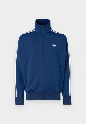 Navy blue track jacket with a high collar, zip front, and white stripes down the sleeves. Features a small white logo on the chest.