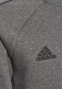 Felpa grigia realizzata in misto cotone, con scollatura rotonda, design elegante e logo Adidas ricamato in nero sul petto.