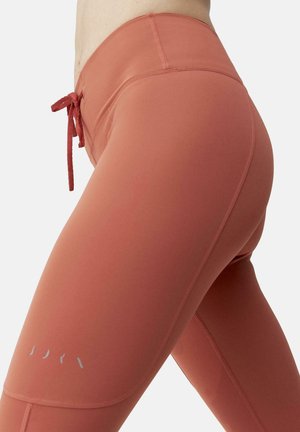 Hoogtaille, aansluitende leggings in een stofroze kleur. Gemaakt van rekbare stof met een trekkoord en minimale reflecterende details.