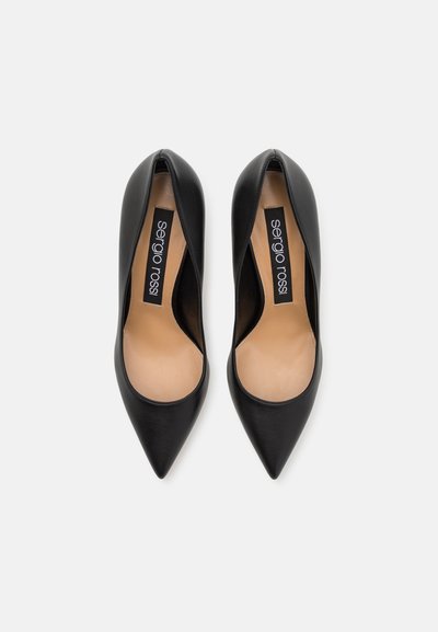 Escarpins noirs en cuir à bout pointu avec une texture lisse, présentant une découpe basse et une semelle intérieure de marque. La semelle a un design classique.