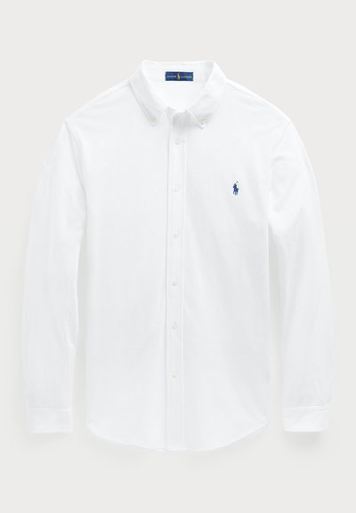 Balta, ilgomis rankovėmis marškiniai, pagaminti iš medvilnės, su mygtukų apykakle ir mažu mėlynu polo logotipu krūtinėje. Lygus audinys, klasikinis fasonas.