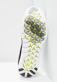 Semelle de chaussure présentant une base blanche avec un motif en nid d'abeille agrémenté d'accents gris et jaunes. Surface texturée pour une meilleure adhérence et traction.