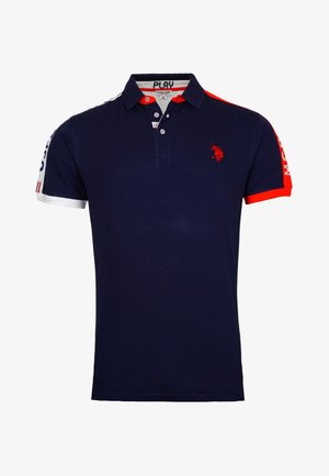 Polo bleu marine avec des accents rouges et blancs, logo rouge brodé sur la poitrine, col boutonné et texte imprimé sur les manches.