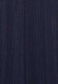 Námořnická modrá skládací látka s texturovaným povrchem, který obsahuje malé, vyvýšené tečky rovnoměrně rozmístěné. Měkký, lehký a splývavý design.