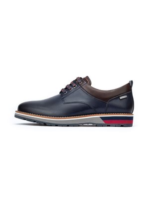 Chaussure en cuir à lacets de couleur bleu foncé avec des accents marron, semelle à motifs gris et rouge, et détails de couture sur le dessus.