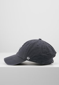 Casquette de baseball en coton gris avec une visière courbée et un logo brodé. Straps ajustables à l'arrière. Texture lisse, design décontracté.