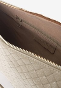 Beige strukturiertes Lederetui mit einem Reißverschluss. Das Innere verfügt über ein glattes, kastanienbraunes Futter und ein kleines Reißverschlussfach.