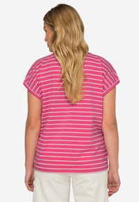 Camiseta de manga corta, rosa con rayas gris claro. Tela de algodón suave, corte holgado, escote redondeado y mangas ligeramente oversize.